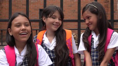 Kız öğrencilerin okul üniformaları giyen gülüyor