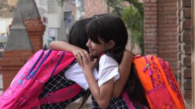 Kız öğrenci sırt çantaları ile sarılma