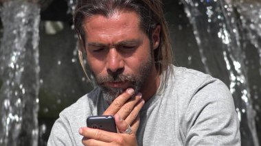 Yakışıklı İspanyol erkek kullanarak telefon