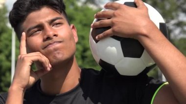 Atletik genç erkek futbol oyuncusu düşünme