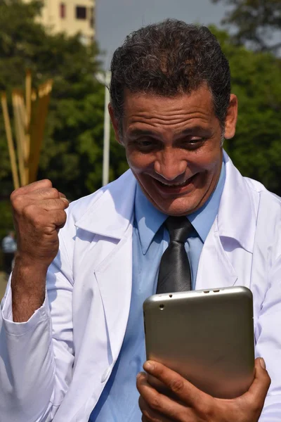 Männlicher hispanischer Arzt mit Tablette und Glück — Stockfoto