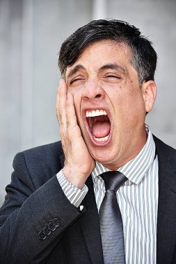 Takım elbise giymiş uykulu genç Kolombiyalı iş yürütme