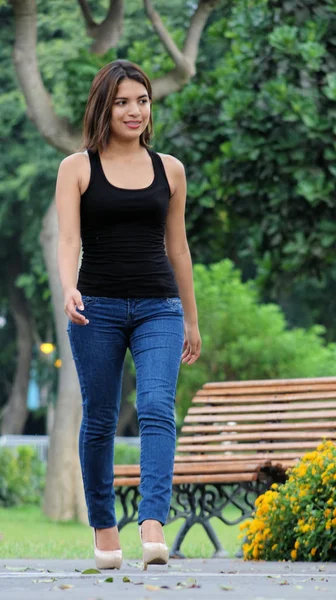 Ragazza ispanica e felicità indossando Blue Jeans a piedi nel parco — Foto Stock