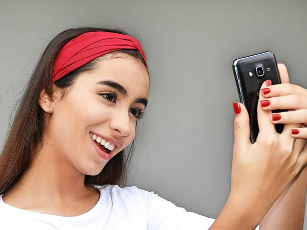 Guapa chica adolescente usando teléfono celular y feliz — Foto de Stock