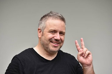 Tıraşsız erkek ve barış işareti