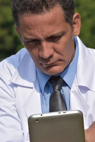 Médico hispano masculino serio usando tableta — Foto de Stock