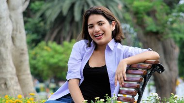 Parkta oturan neşeli güzel kişi