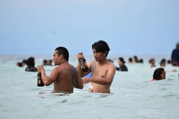 Мужчины пьют алкогольные напитки на пляже — стоковое фото