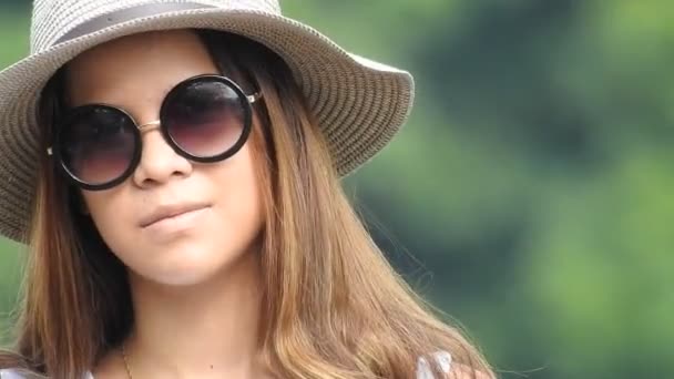 Uma menina muito adolescente usando óculos de sol — Vídeo de Stock