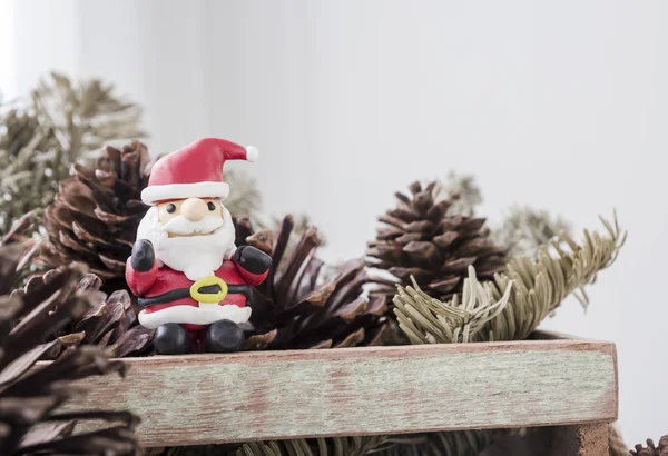 Decoración navideña de Santa Claus y conos de pino en caja de madera —  Fotos de Stock