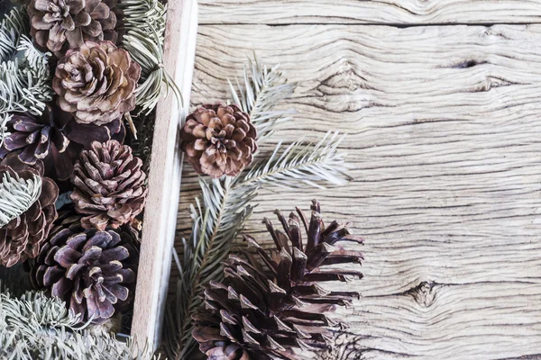 Weihnachtsdekoration aus Tannenzapfen in Holzkiste — Stockfoto