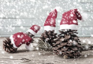 Çam kozalakları ahşap arka plan üzerinde Noel şapka ile