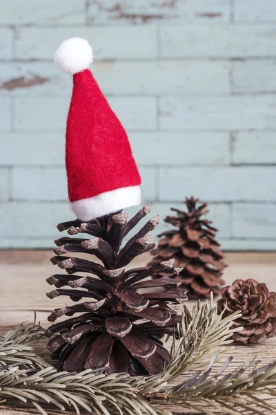 在木头上的圣诞帽与松果 — 图库照片