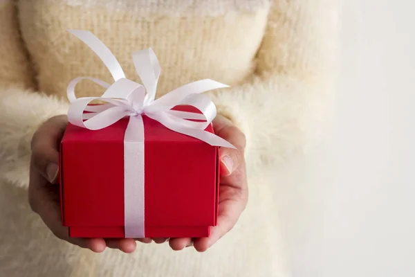 Joven mujer manos sosteniendo caja de regalo rojo — Foto de Stock