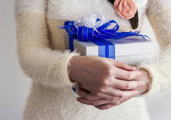 Mujer joven abrazo caja de regalo de plata con cinta azul y blanco — Foto de Stock