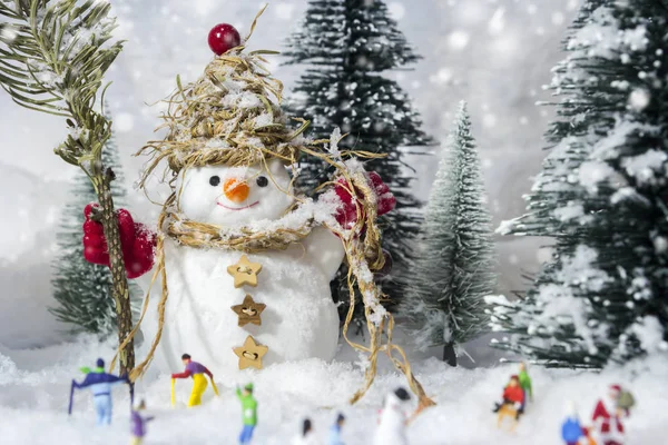 Muñeco de nieve y personas en bosques de pinos durante el invierno —  Fotos de Stock