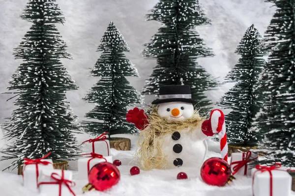 Muñeco de nieve en el bosque de pinos con nieve para Navidad —  Fotos de Stock