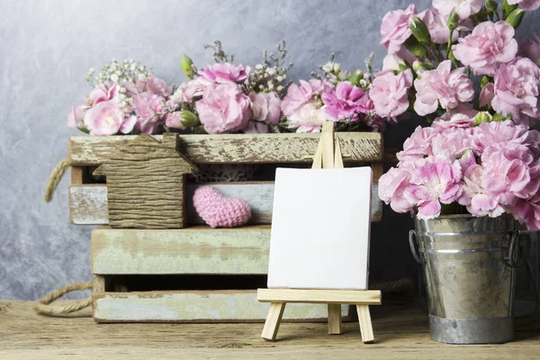 Flores de clavel rosa y marco de lienzo en blanco en pintura de caballete —  Fotos de Stock