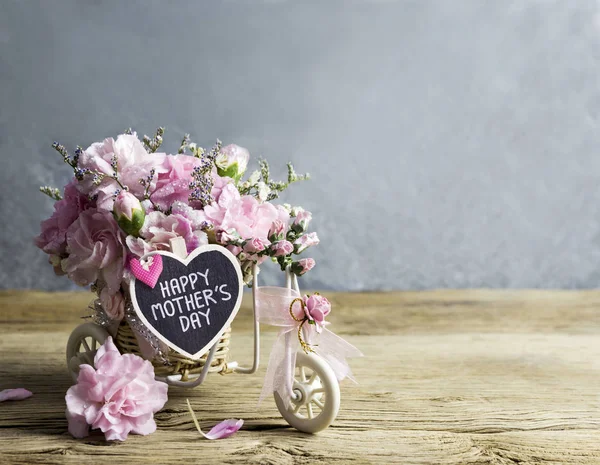 Pink carnation in bicycle with happy mothers day letter — Stock Photo, Image