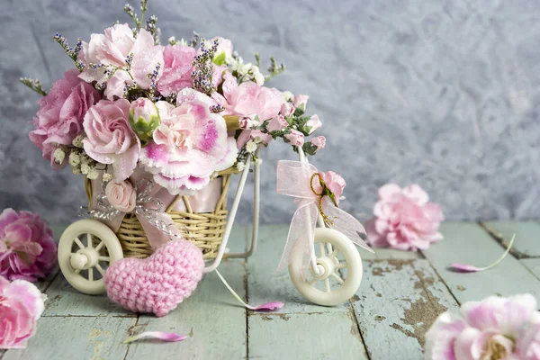 Pink carnation in bicycle with pink knitting wool heart — Stock Photo, Image