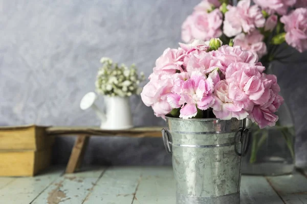 Çinko kova tablo ahşap üzerine pembe karanfil çiçek — Stok fotoğraf