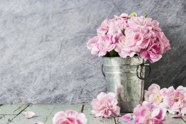Eski ahşap çinko kovanın içinde pembe karanfil çiçek