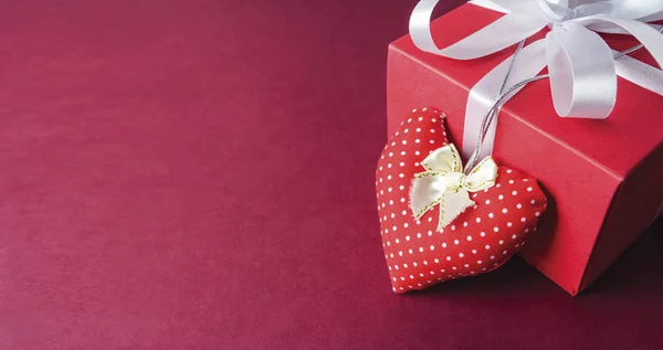 Kağıt arka plan üzerinde kırmızı kumaş kalp ve hediye kutusu — Stok fotoğraf