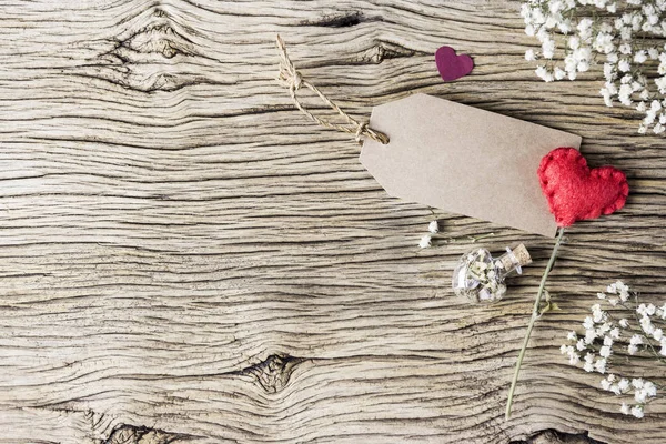 Conceito de amor de etiqueta de papel marrom em branco com coração vermelho e flores na madeira velha para dia dos namorados e casamento — Fotografia de Stock