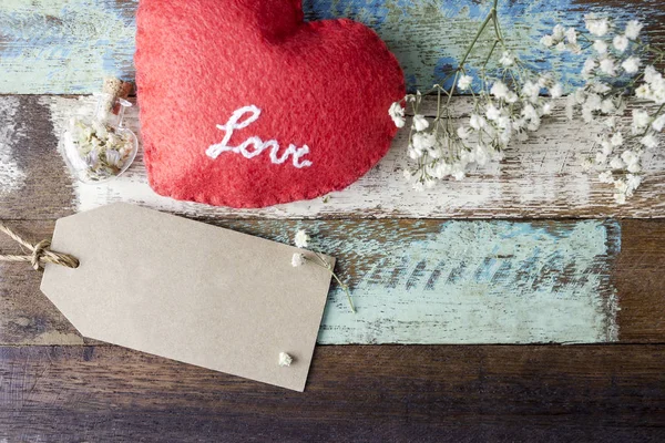 Liebe Konzept der braunen Papieranhänger mit rotem Herz und Blumen auf altem Holz für Valentinstag und Hochzeit — Stockfoto