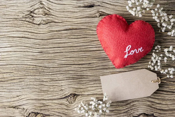 Liebe Konzept der braunen Papieranhänger mit rotem Herz und Blumen auf altem Holz für Valentinstag und Hochzeit — Stockfoto