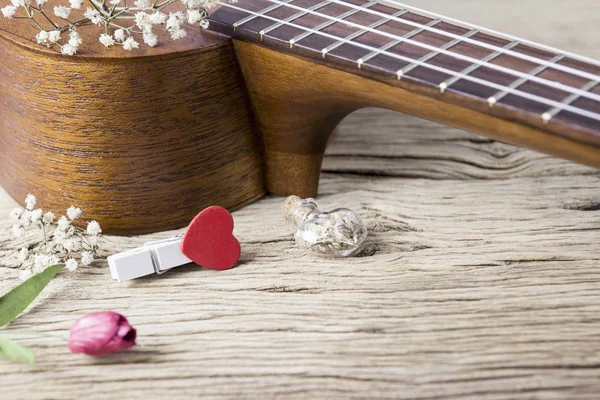 Música amante concepto de ukelele y rojo corazón ropa peg en madera vieja — Foto de Stock