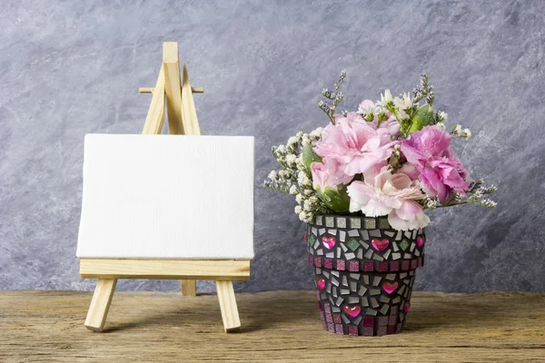 Ροζ γαρύφαλλο λουλούδια σε γλάστρα ψηφιδωτό και κενό καμβά πλαίσιο σε καβαλέτο ζωγραφικής — Φωτογραφία Αρχείου