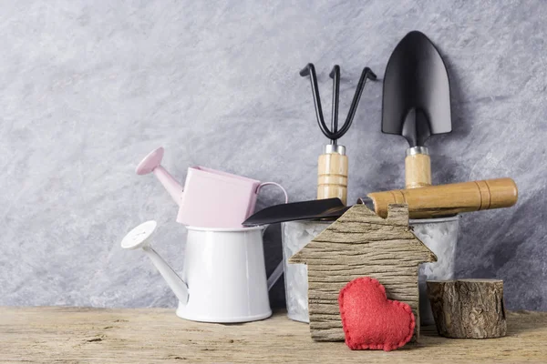 Hogar y jardín concepto de hogar de madera con corazón rojo y herramientas de jardinería en madera vieja — Foto de Stock