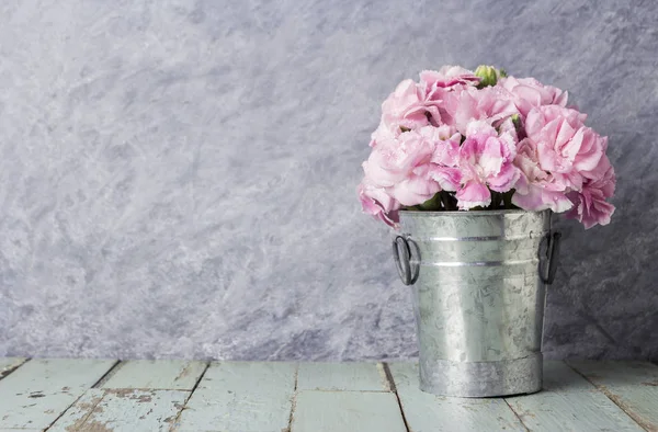 Flores de clavel rosa en cubo de zinc sobre madera vieja —  Fotos de Stock