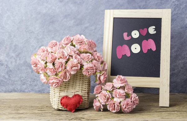 Mothers day concept of paper carnation flowers with love mom on black board — Stock Photo, Image