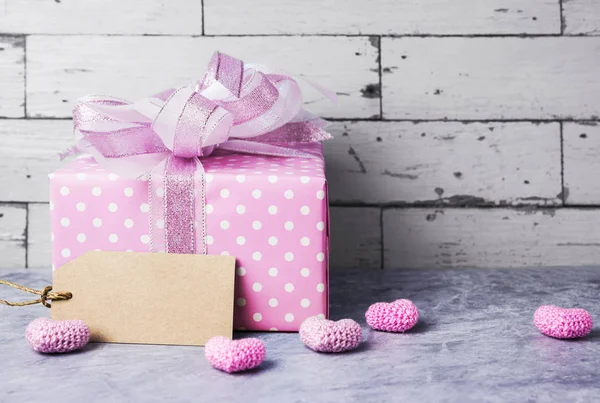 Rózsaszín ajándék doboz és üres barna papír címke, rózsaszín szív — Stock Fotó