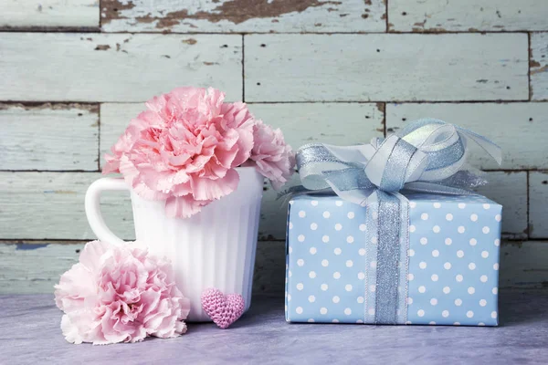 화이트 컵 및 선물 상자에 핑크색 카네이션 꽃의 어머니 날 개념 — 스톡 사진