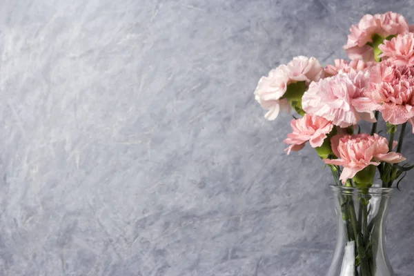 Pink carnation flowers in clear bottle with copy space — Stock Photo, Image