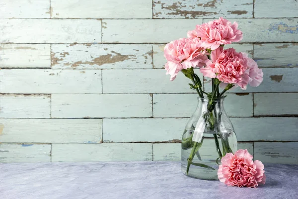 Flores de cravo rosa em garrafa de vidro com espaço de cópia — Fotografia de Stock