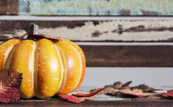 Erntedank und Halloween-Konzept von Kürbis mit Ahornblättern auf Holzstuhl — Stockfoto