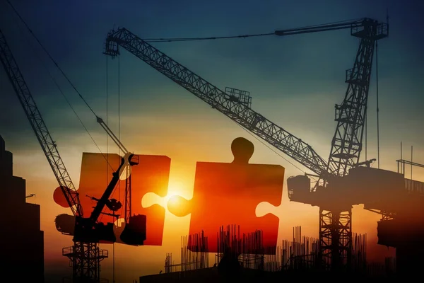 Teamwork concept of silhouette construction site and jigsaw puzzle at sunset — Stock Photo, Image