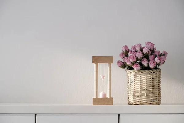 O conceito de amor de ampulheta e papel rosa aumentou a flor na cesta — Fotografia de Stock
