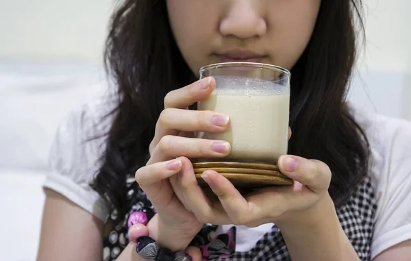 Young woman drinking soybean milk in the bedroom
