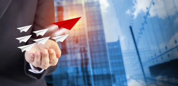 Leadership concept of business woman hand with paper planes on modern building in the city with sunlight — Stock Photo, Image