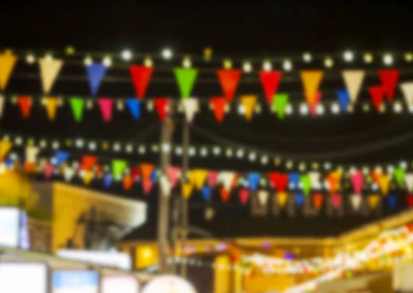 Abstrakter verschwommener Hintergrund von Wimpeln und Glühbirnendekoration beim Nachtfest — Stockfoto
