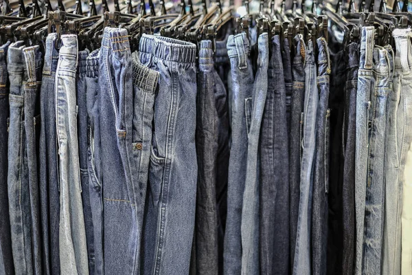 Row of hanged blue jeans pants in shop — Stock Photo, Image