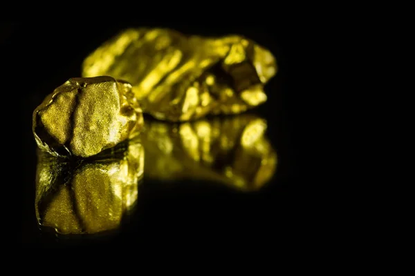 Nuggets de ouro sobre fundo preto com reflexão — Fotografia de Stock