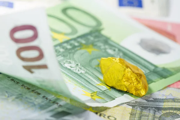 Gold nugget on euro banknotes — Stock Photo, Image