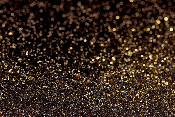 Abstrakcja ciemny złoty brokat tło z świecące światła i miękki bokeh, uroczysty kolory — Zdjęcie stockowe
