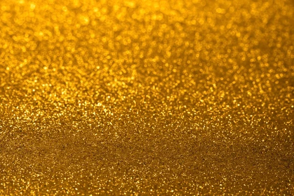 Abstract golden glitter background with shining light and soft bokeh, festive colors — Stock Photo, Image